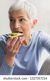 Closeup Portrait Of Beautiful Mature Woman Eating Healthy Nutritious Fresh Vegan Toast With Avocado, Healthy Breakfast Concept