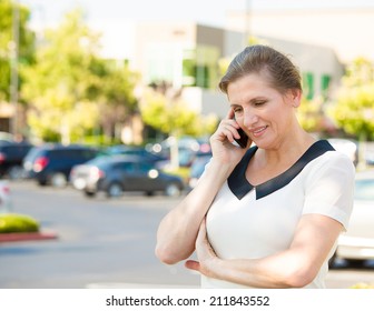 Closeup Portrait Beautiful Mature Woman Or Businesswoman In Her Forties Talking On Cell Phone Outside, Having Pleasant Conversation Receiving Good News, Outdoors Background. Positive Facial Expression