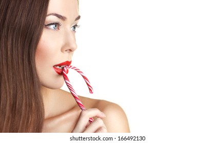 close-up portrait of a beautiful nude adult girl with long brown hear holding stick of candy cane on white background