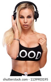 close-up portrait of beautiful sexy blonde DJ woman on white background in studio wearing headphones.
