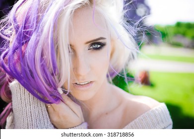 Close-up Portrait Of A Beautiful Sexy Young Blonde Girl Hipster With Lilac And Pink Hair On The Background Of Blooming Lilacs, Posing With Bright Makeup