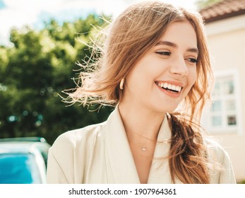 Closeup portrait of beautiful smiling brunette model. Trendy female posing in the street background at sunset. Funny and positive woman having fun outdoors