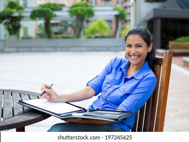 Closeup Portrait, Beautiful, Smiling Young Business Woman In Blue Shirt, Sitting, Taking Notes Outside, Isolated Trees Background