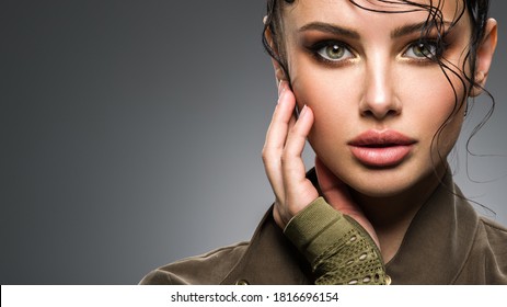 Closeup Portrait Of A Beautiful Young Fashion Woman With Glamour Makeup Posing At Studio. Portrait Of An Attractive Woman In Green Clothes.