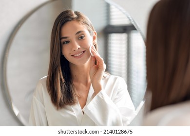 Closeup Portrait Of Beautiful Young Lady Cleansing Skin With Cotton Pad Near Mirror, Attractive Millennial Woman Smiling To Her Reflection, Enjoying Self Care Routine At Home, Selective Focus - Powered by Shutterstock