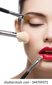 Closeup Portrait Of Beautiful Young Woman With Makeup Brushes. Red Lips. Isolated Over White Background.