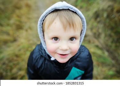 Close-up portrait of beauty blondie baby boy with brow eyes in warm winter clothes