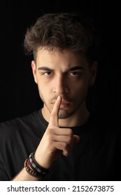 close-up portrait black background young male handsome model with hand shut up don't talk listen expression visual expression - Shutterstock ID 2152673875
