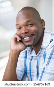Close-up portrait of a black man smiling and looking at camera