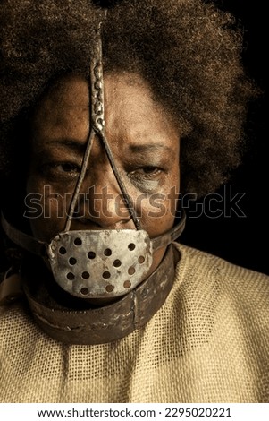Close-up portrait of a black woman wearing an iron mask on her face to represent the slave Anastacia. Slavery in Brazil.