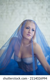 Close-up Portrait Of A Blonde Girl In A Blue Ball Gown