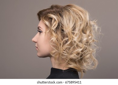 Close-up portrait of blonde with hair short hair and clean skin isolated on grey background