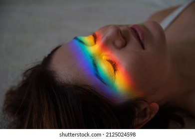 Close-up Portrait Of Caucasian Woman With Ray Of Rainbow Light On Her Face. 