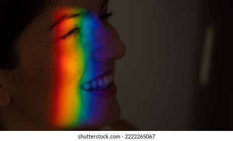 Close-up Portrait Of Caucasian Woman With Ray Of Rainbow Light On Her Face. 