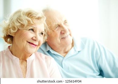 Close-up portrait of a charming elderly woman with her husband on background
