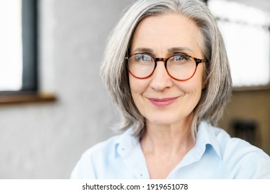 Close-up Portrait Of Charming Positive Mature Elderly Business Woman Wearing Stylish Eyeglasses And Smart Casual Attire. Senior Confident Grey-haired Lady Looks At The Camera. 