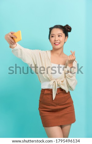 Close-up portrait of cheerful lady making taking selfie isolated over bright vivid blue background