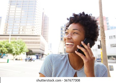 Closeup Portrait Of A Cheerful Young Woman Making A Phone Call Outdoors In The City 
