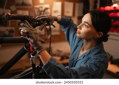 Close-up portrait of concentrated cycling mechanic woman checking and repairing bicycle handlebar with tools while working in bike repair workshop with authentic interior. maintenance of bike. - Powered by Shutterstock