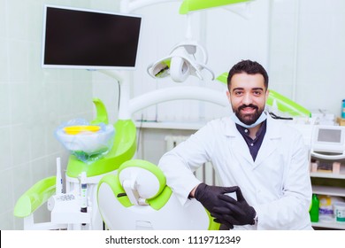 Closeup portrait of confident healthcare professional with arms folded standing next to white patient chair - Shutterstock ID 1119712349