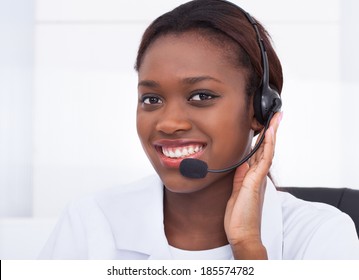 Close-up Portrait Of Confident Receptionist Using Headset In Hospital