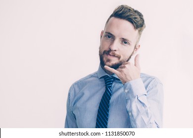 Closeup portrait of content young business man looking at camera and making call me gesture. Isolated front view on white background.
