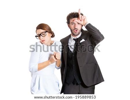 Closeup portrait couple, business people. Bully husband, man standing upfront, angry, giving bully sign with hand, shy, timid wife, nerdy woman with glasses, isolated white background. Human emotions