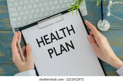 Closeup Portrait Of Cropped Health Care Professional With Stethoscope And Red Tie, Holding A Sign Which Says Health Plan And Showing Space For Text With Pen