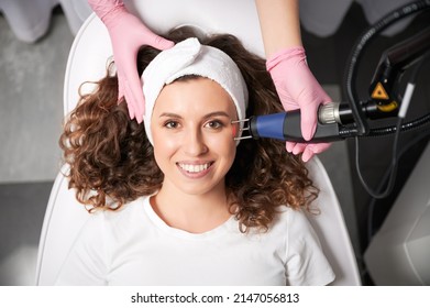 Close-up portrait of curly girl with old post acne which removing by laser face polishing. The process of photothermolysis, warming skin in hardware cosmetology for skin cleaning. - Shutterstock ID 2147056813