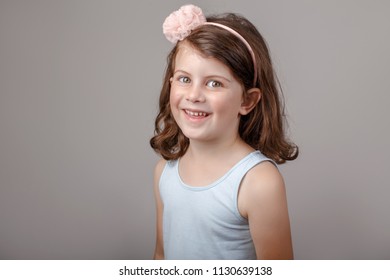 Closeup Portrait Of Cute Adorable White Brunette Caucasian Preschool Girl Making Faces In Front Of Camera. Child Smiling Laughing Posing In Studio On Plain Light Background. Kid Expressing Emotions