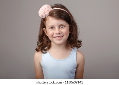 Closeup Portrait Of Cute Adorable White Brunette Caucasian Preschool Girl Making Faces In Front Of Camera. Child Smiling Laughing Posing In Studio On Plain Light Background. Kid Expressing Emotions