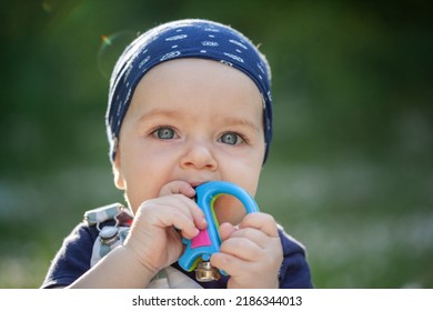 Closeup Portrait Cute Baby Is Sitting On A Linen Blanket And Playing With Colored Educational Toys. Products For Children. Child Teething. Child Care.