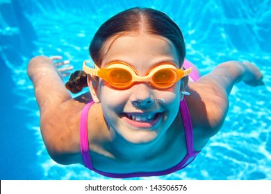 Close-up portrait of the cute girl swimming underwater and smiling