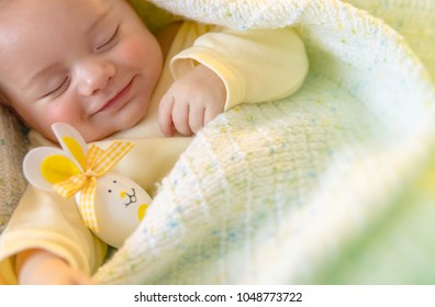 Closeup Portrait Of A Cute Little Baby Sleeping With Decorative Egg Toy, Traditional Symbol Of Easter Holiday, Love And Religion Concept