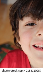 Closeup Portrait Of Cute Young Kid With Eyes Wide Open And Hair On His Forehead. Only Half Of The Boy Face Is Shown