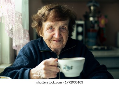 Close-up Portrait Of An Elderly Woman Drink Tea In Her Home. 