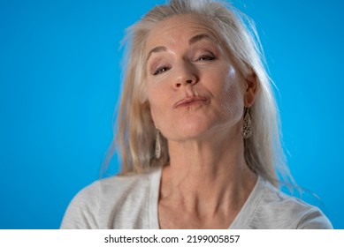 Close-up Portrait Of Excited Amazed Beautiful Mature Woman Send Air Kiss On Solid Blue Color Background