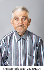 Closeup Portrait Of Expressive Old Man  Over Gray Background