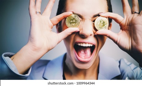 close-up portrait fashioned woman in business suit have fun with two bitcoin coins.