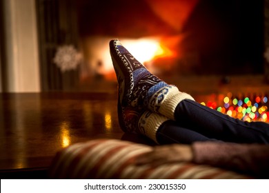 Closeup portrait of feet at woolen socks warming at fireplace in winter