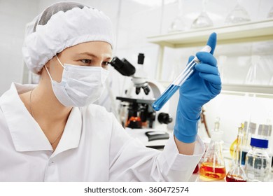 Closeup portrait female scientist holding conical tube with liquid solution, laboratory experiments, isolated lab background. Forensics, genetics, microbiology, biochemistry