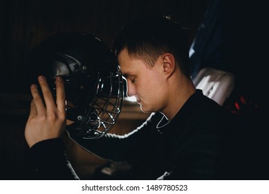 Closeup Portrait Of A Focused Hockey Goalie. Sports Photography. A Professional Ice-hockey Player In Uniform With Protection And Helmet.