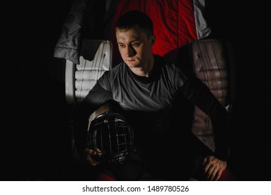 Closeup Portrait Of A Focused Hockey Goalie. Sports Photography. A Professional Ice-hockey Player In Uniform With Protection And Helmet.