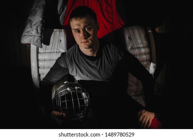 Closeup Portrait Of A Focused Hockey Goalie. Sports Photography. A Professional Ice-hockey Player In Uniform With Protection And Helmet.