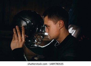 Closeup Portrait Of A Focused Hockey Goalie. Sports Photography. A Professional Ice-hockey Player In Uniform With Protection And Helmet.