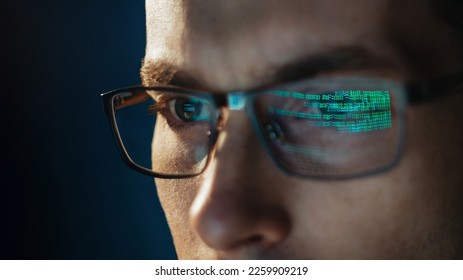 Close-up portrait of focused software engineer wearing eyeglasses looking at computer screen working with big data. Programming code reflecting in glasses. Data science, Machine Learning, AI concept - Powered by Shutterstock