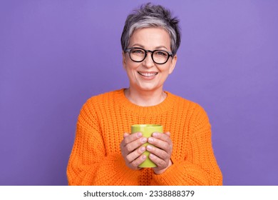 Closeup portrait of friendly model senior woman grey short hair hold green mug coffee break cappuccino isolated on violet color background - Powered by Shutterstock