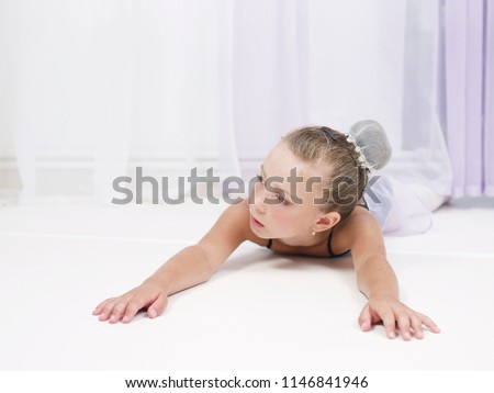 Close-up portrait of girl resting and lying down in a dance class.