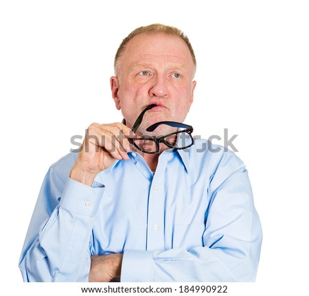 Closeup portrait, goofy senior mature business man playing, biting black glasses, bored out of his mind, isolated white background. Negative emotion facial expression feelings, reaction, attitude