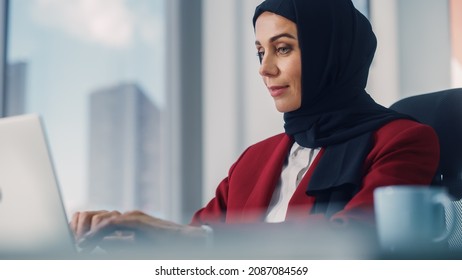 Close-up Portrait of Gorgeous Muslim Businesswoman Wearing Burka Sitting at Her Desk Working on Laptop Computer in Office. Successful Corporate CEO Plan Investment Strategy for e-Commerce Startup - Shutterstock ID 2087084569